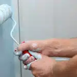 Rouleau de peinture tenu à 2 mains