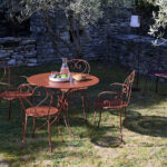 Table et chaises en fer de couleur ocre dans jardin