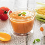 Aliments bio pour bébés, Bol de soupe tomate, épis de maïs derrière