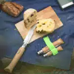 Planche avec un gâteau coupé par un couteau pliant opinel
