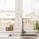 Fenêtre blanche devant un évier, pot décoratif