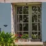 Fenêtre aux volets ouverts, bac a fleurs sur rebord