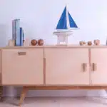 Bateau miniature en décoration sur un meuble en bois