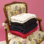 3 pulls pliés posés sur un fauteuil