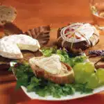 Fromages présentés avec feuilles d'arbres et raisins blancs