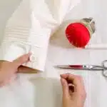 Couture d'un bouton sur une manche de chemise