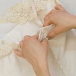 Assemblage des boutons sur une robe de mariée