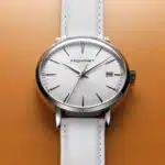 une montre blanche sur fond orange