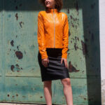 Femme avec veste en cuire orange et jupe noire