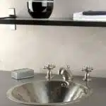 lavabo et robinetterie inox sur plan de travail gris