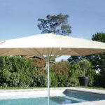 Grand parasol ouvert au bord d'une piscine