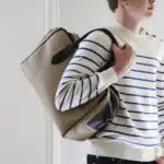 Homme en marinière portant un sac à l'épaule