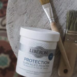 Pot protection de surface peintes de Libéron posé sur tabouret avec un pinceau