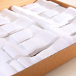 Nœuds blancs en ruban rangés dans une boite en carton