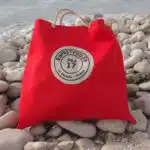 Sac de plage rouge sur une plage en galets