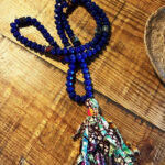 collier en perles bleues et bandelettes de tissus colorées