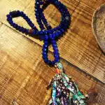 collier en perles bleues et bandelettes de tissus colorées