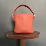 Sac orangé posé sur une petite table ronde