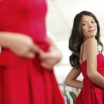 Femme se regardant dans un miroir avec une robe rouge