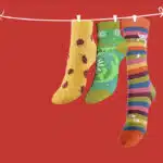 Chaussettes pendues à un fil sur fond rouge