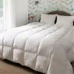 Couettes naturelles, blanche en duvet sur un lit