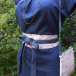 Ceinture en tissus fleuri portée sur robe bleu et petit sac assorti