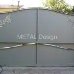 Portail coulissant, gris avec feuillage découpé dans les portes.