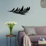 Décorations murales en métal sur un mur gris, un canapé, un pot de fleurs posé sur une petite table