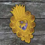Décoration croix de Marie jaune sur fond bois