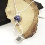 un bijou diffuseur d'huiles essentielles en pendentif sur ecorce de bois