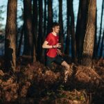 Homme avec t-shirt rouge courant dans la forêt