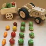 Tracteur en bois avec une remorque et des légumes en couleur