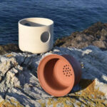 Pots en céramique posés sur des pierres devant la mer