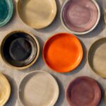 Vaisselle artisanale : assiettes plates en poterie de différentes couleurs