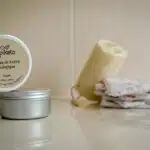 1 pot de cosmétique rond, un savon posé sur du carrelage