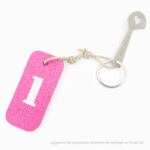 un porte clé rose avec le chiffre1, une clé jeton de caddie