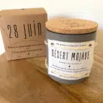 Bougies naturelles dans un pot avec un couvercle en liège et un cube en bois à côté