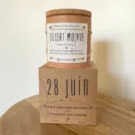 une bougie dans un pot avec un couvercle en liège posée sur un cube en bois
