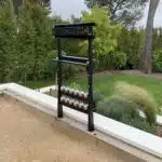 un compteur de score fixé sur un muret un jardin derrière