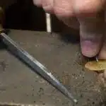 un poinçon, une main tenant un bijou