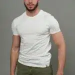 homme avec T-shirt manche courte blanc, pantalon kaki, brs le long du corps