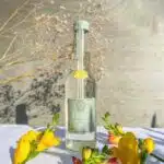 bouteille de limonade avec des fleurs jaunes posées sur une table