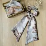 chouchou pour cheveux et une boîte carré posés sur une table