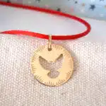 Médaille ajourée accrochée à un cordon rouge